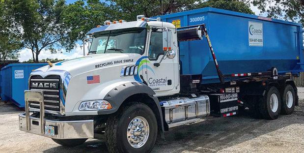 Truck carrying dumpster in Coastal Waste's Yard in West Palm Beach, FL
