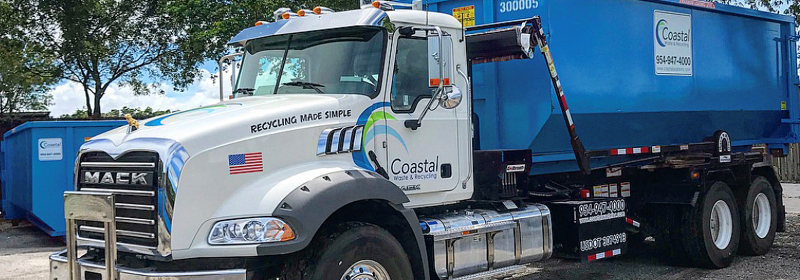 Truck carrying dumpster in Coastal Waste's Yard in West Palm Beach, FL