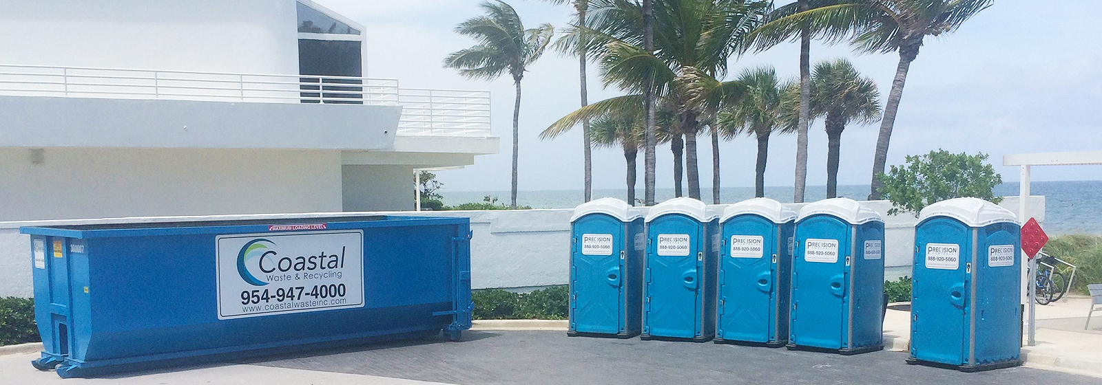 Portable Restroom by Precision Portables shown by the beach next to Coastal Waste roll off dumpster